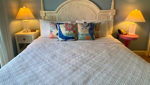 A bed with a white headboard and two bedside tables, each with a lamp and a phone. - Harbour House At The Inn Unit 211 1 Bedroom Condo by RedAwning (Fort Myers Beach)