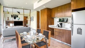 Eine moderne Küche mit Holzausstattung, einem Einbaukühlschrank und einem Essbereich mit Glastisch und Stühlen.