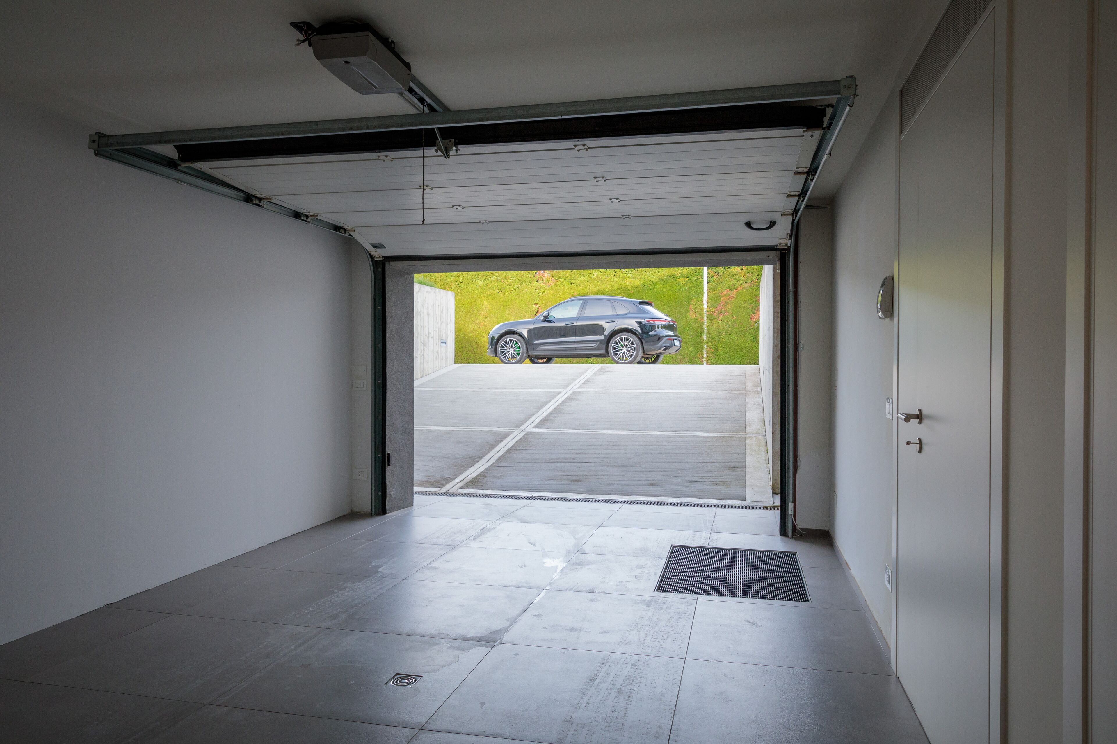A garage with a car parked outside.