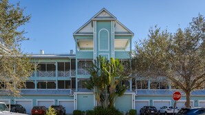 A two-story building with a light blue exterior, a balcony on the second floor, and a stop sign in the foreground. - ~the Bonita Paddle Efficiency~ Your Home Away From Home In Paradise 1 Bedroom Condo by RedAwning (Bonita Springs)