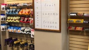 Un pasillo con productos de bar, fruta, aperitivos y postres congelados, todo debidamente etiquetado.