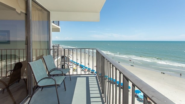 A balcony with a view of a beach.