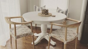 A round dining table with four chairs, a woven placemat, and a glass on the table. - 3 bedroom, 2 bath luxury home a stones throw from Thames (Newport)