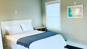 A bedroom with a bed, a ceiling fan, a window with blinds, a bedside table, and a wall-mounted picture. - 3 bedroom, 2 bath luxury home a stones throw from Thames (Newport)
