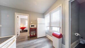 Eine kleine Küche mit Kühlschrank, Mikrowelle und einer Speisekammer.