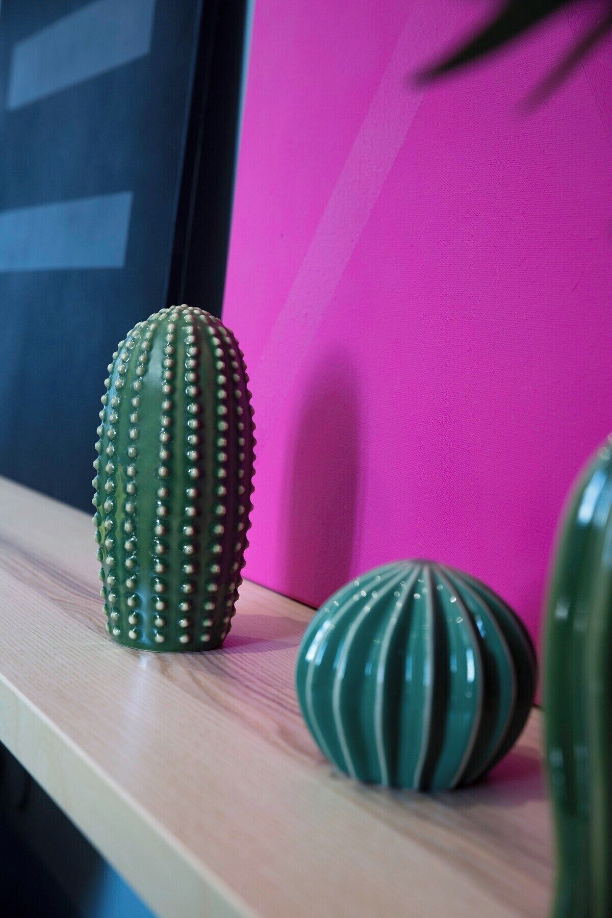 A cactus and a decorative bowl on a shelf.