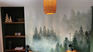 A bedroom with a forest-themed wall mural, a bed with striped pillows, a shelf with decorative items, and two bedside lamps. - Diamond Forest - 8 Full Beds Summercard Included (Kaprun)