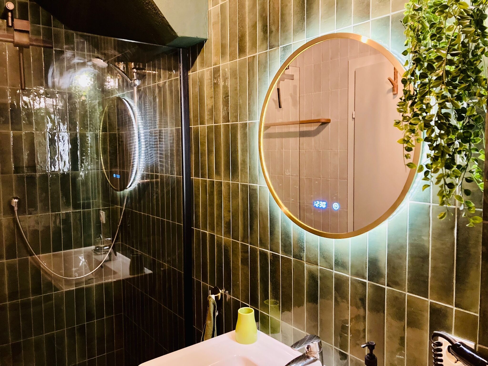 Un bagno con uno specchio grande, un lavandino e una doccia.