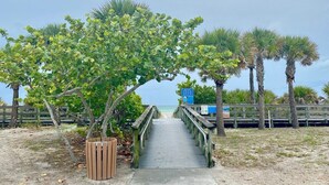 A wooden pathway leading to a beach with palm trees and a wooden fence. - Only 2.5 miles to Beach + Heated Saltwater Pool Included! (Englewood)