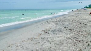 A beach with clear turquoise water, a sandy shore, and a few people enjoying the water. - Only 2.5 miles to Beach + Heated Saltwater Pool Included! (Englewood)