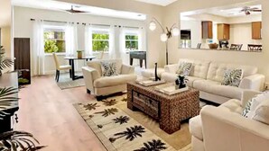 A spacious living room with a large sofa set, a coffee table, and a dining area with a table and chairs. - Only 2.5 miles to Beach + Heated Saltwater Pool Included! (Englewood)