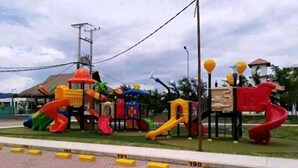 A playground with various play structures including slides and climbing areas.
