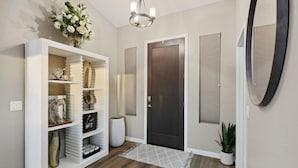 A hallway with a white console table, a dark door, and a potted plant. - Luxury Home, Beautiful Neighborhood, Spacious for Family, with Pool/Spa.  (Glendale)