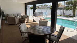A patio with a pool, outdoor furniture, and a view of the neighborhood. - Malvia’s Oasis- Cozy home with a Private Pool (Englewood)