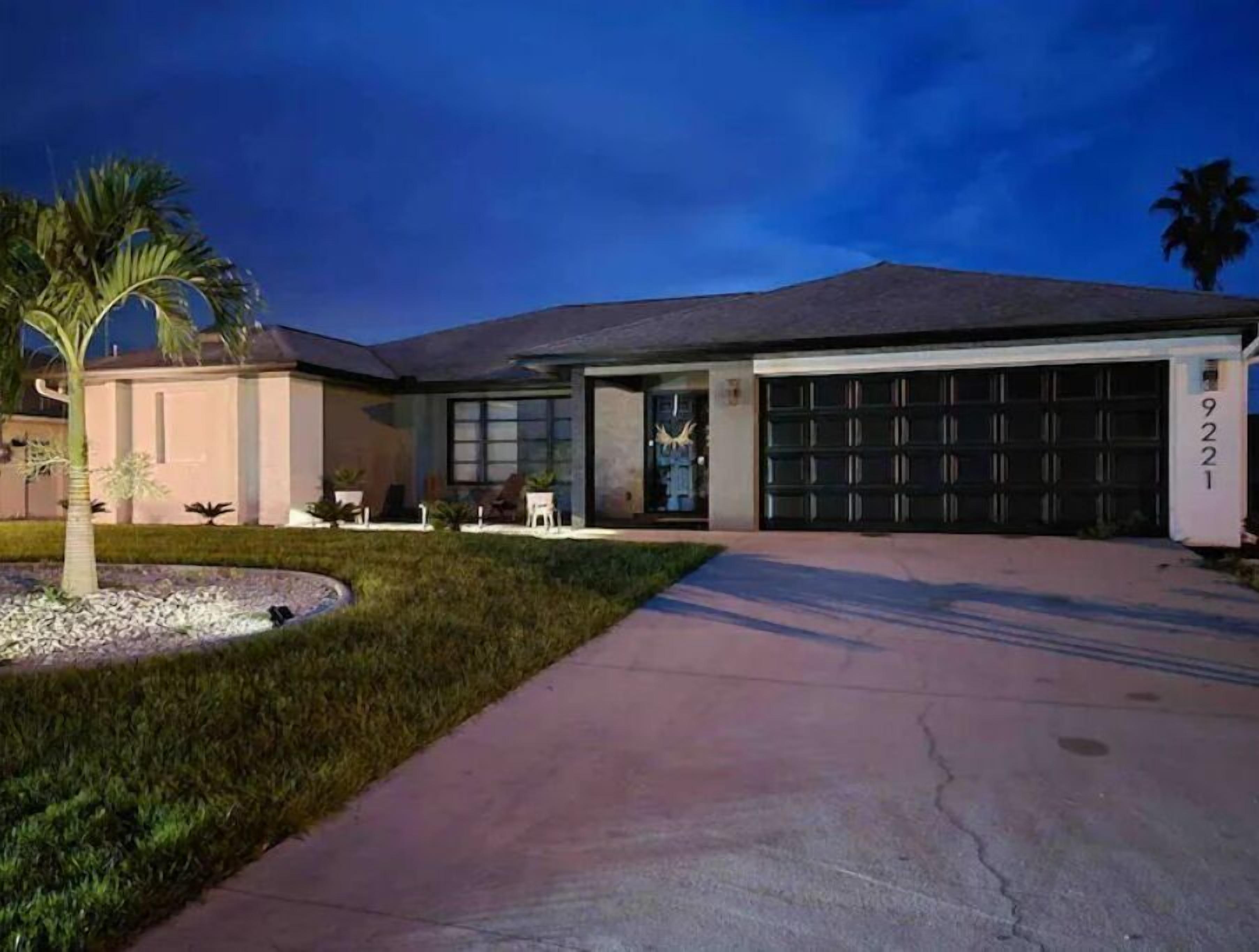 Une maison moderne dotée d’un garage, d’une allée et d’une pelouse bien entretenue.