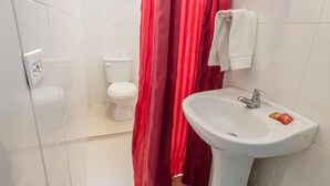 Een badkamer met een witte wastafel, toilet en douchegordijn.