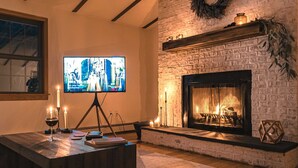 Una sala de estar acogedora con chimenea, televisor y una mesa de centro.