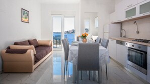 Un salon moderne avec un canapé et une table à manger pour quatre personnes.