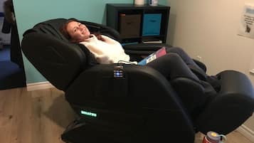 Relax in a serene space with a massage chair and amenities at your fingertips.