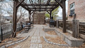 A covered patio area with a pergola, seating, and a fireplace. - The West Nest 2 -Families, 2 Kings, Game Room (Canyon)