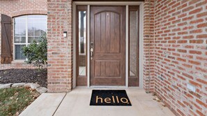 A brick house with a wooden front door and a doormat that reads "hello". - The West Nest 2 -Families, 2 Kings, Game Room (Canyon)