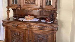 Un grand meuble en bois orné de sculptures complexes et doté de nombreux tiroirs.
