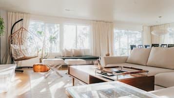 A modern living room with a sofa, coffee table, and hanging chair.