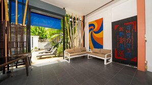 A modern interior with a seating area, a staircase, and a large abstract painting.