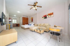 A modern hotel room with a bed, sofa, dining table, and a TV. - Jungceylon Villa in Patong by Lofty (Patong)