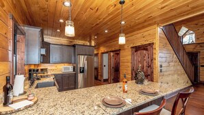 A kitchen with granite countertops, stainless steel appliances, and wooden cabinetry.