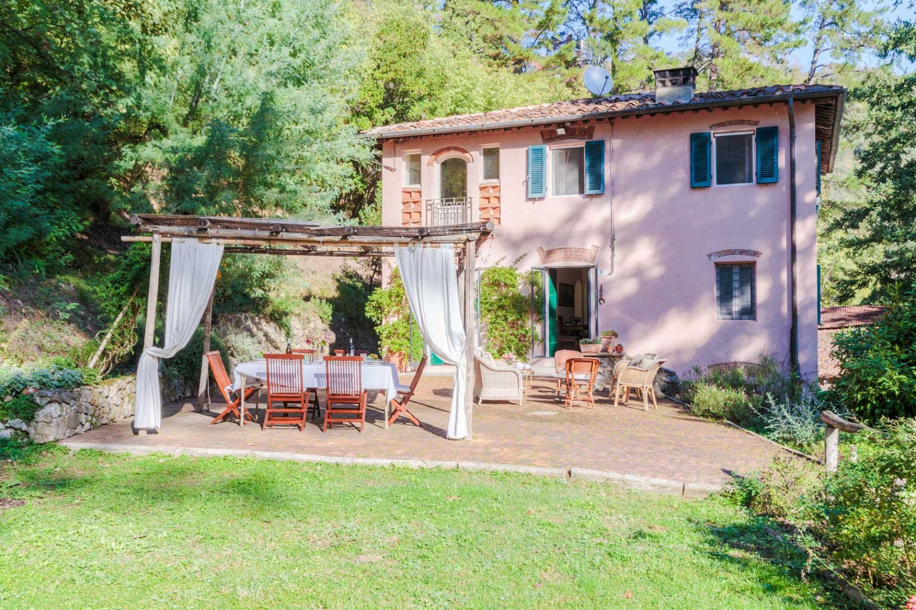 Une villa de style rustique dotée d’un patio, d’un espace salon extérieur et d’une pergola.