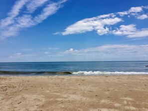 Una playa con cielo despejado y mar tranquilo.
