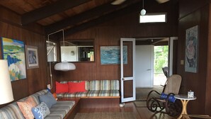 Un salon chaleureux avec un canapé, un tapis, une table et un vélo.