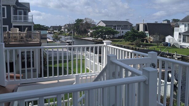 A residential area with a river, houses, and a white fence. - Canalfront Home in South Bethany - new kitchen! (Bethany Beach)