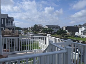 A residential area with a river, houses, and a white fence.
