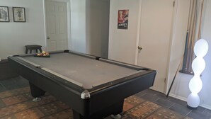 A pool table with balls, a door, and a poster on the wall. - Canalfront Home in South Bethany - new kitchen! (Bethany Beach)