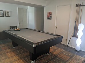 A pool table with balls, a door, and a poster on the wall. - Canalfront Home in South Bethany - new kitchen! (Bethany Beach)