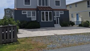 A two-story building with a central entrance, multiple windows, and a small porch area. - Canalfront Home in South Bethany - new kitchen! (Bethany Beach)