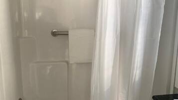 Un baño con bañera, inodoro y cortina de ducha.