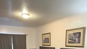 A hotel room with two beds, a large window with curtains, and two framed pictures on the wall. - Entrance to the Florida Keys, The Historic Hotel Redland (Homestead)