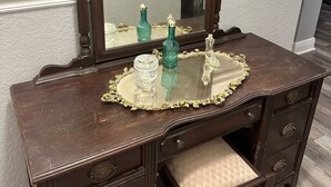 A wooden vanity with a mirror, a small sink, and a decorative tray. - Entrance to the Florida Keys, The Historic Hotel Redland (Homestead)