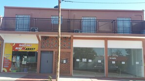 A two-story building with a storefront labeled "Martinez Mini Market" on the ground floor. - RUKA Apart  (Chilecito)