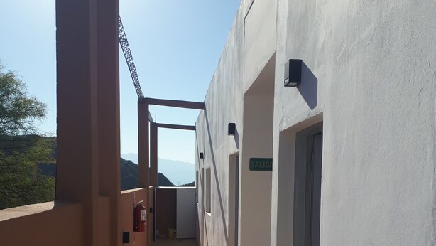 A corridor with tiled flooring, a fire extinguisher, and a sign reading "SALIDA" (exit). - RUKA Apart  (Chilecito)