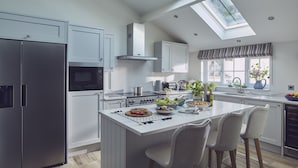 Una cocina moderna con una isla central, electrodomésticos de acero inoxidable y un tragaluz.