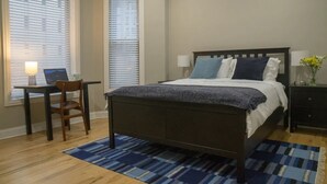 Ein Schlafzimmer mit Bett, Schreibtisch und Stuhl.