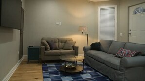 Ein Wohnzimmer mit zwei Sofas, einem Couchtisch, einer Stehlampe und einem Deckenventilator.