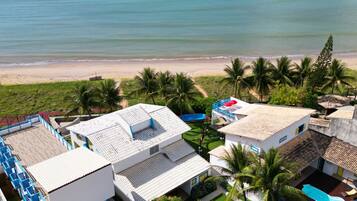 Na praia, areia branca, guarda-sóis, toalhas de praia