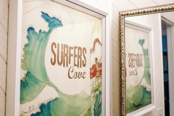 Framed artwork with the text 'SURFERS Cove' and a surfer illustration.