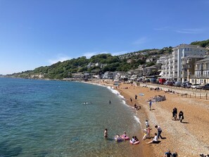 A beach with clear waters, a promenade, and buildings in the background. - Orchard Cottage (Ventnor)