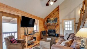 A cozy living room with a fireplace, a television, and a comfortable seating area. - Cupid's Haven: Private Cabin Close To All (Sevierville)